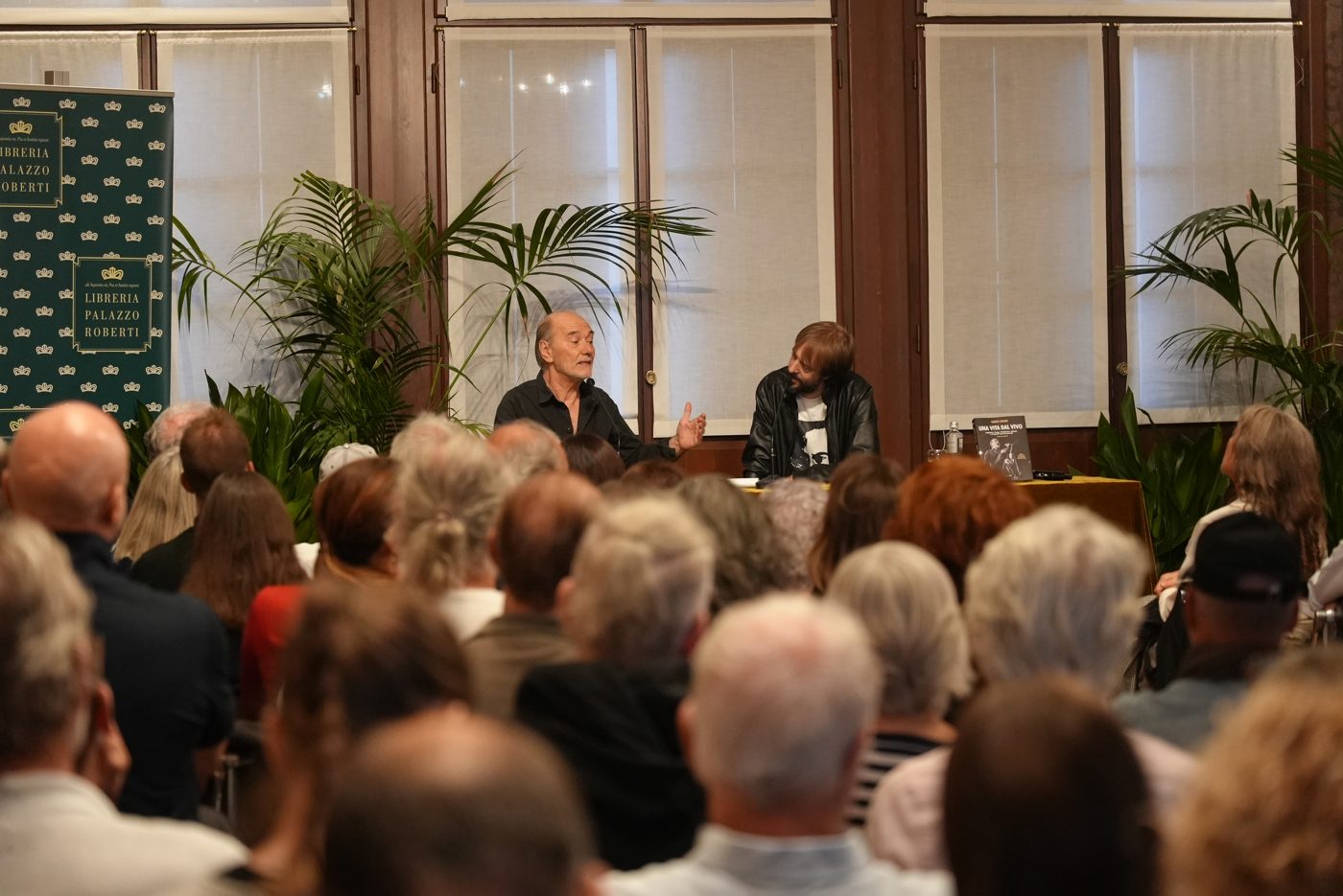 Carlo Casale in conversation in front of the packed hall